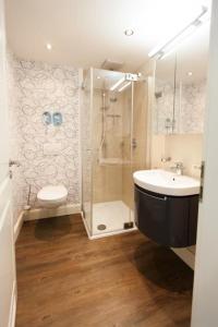 une salle de bain avec douche, lavabo et toilettes dans l'établissement Ferienresidenz Haus Vogelflug Fehmarn-Ostseeferien Strandresidenz Vogelflug 141 App 4 Meerblick, à Fehmarn