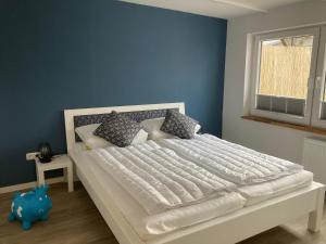 a bedroom with a large white bed with a blue wall at Kleine Meerjungfrau in Fehmarn