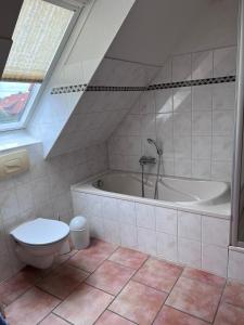 a bathroom with a toilet and a bath tub at FeWo Heinz in Fehmarn