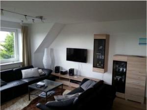 a living room with a couch and a tv at Seeblick in Fehmarn