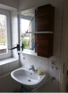 a bathroom with a sink and a mirror and a window at Seeblick in Fehmarn +4 photos