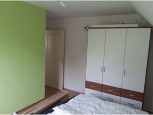 a bedroom with a white bed and a closet at Seeblick in Fehmarn