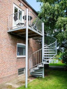 a metal staircase on the side of a brick building at Ferienwohnung Küthe in Fehmarn