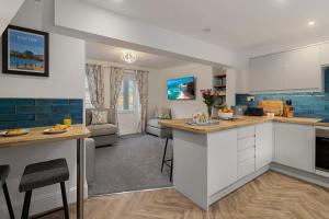 a kitchen with white cabinets and blue tiles at River Exe Hideaway - Balcony over the River in Exeter