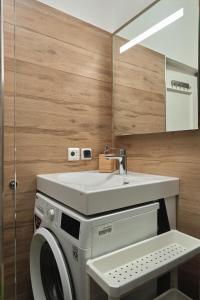 Un baño con lavadora y lavabo. en Cozy apartment near the embankment and the Old Town and free parking in front of the apartment windows, en Riga