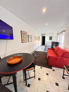 Una sala de estar con un sofá rojo y una mesa. en GENOVA Suites SANT'UGO, en Génova
