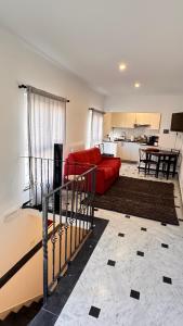 Una sala de estar con un sofá rojo y una cocina. en GENOVA Suites SANT'UGO, en Génova