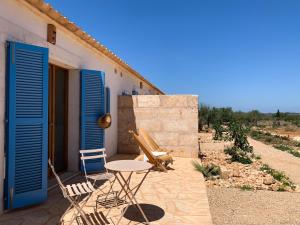 a patio with chairs and a table in front of a building at Blue Door Mallorca in Caʼs Concos
