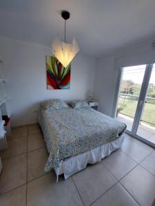 a bedroom with a bed and a painting on the wall at Condominio del Faro - Quequen in Necochea