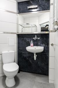 Un baño blanco con inodoro y lavabo. en Polmedica Nowoogrodzka A, en Varsovia
