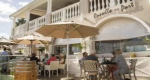 a group of people sitting at a restaurant under an umbrella at 19 Marina Point 4 Bedrooms sleeps 8 in Velddrif