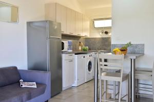 a kitchen with a stainless steel refrigerator and a table at U Paesolu in Sainte-Lucie de Porto-Vecchio