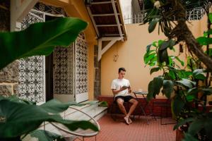 a man sitting on a bench outside a building at Chez Zany Boutique Hostel - Copacabana in Rio de Janeiro +37 photos