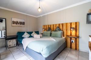 a bedroom with a large bed with a wooden headboard at Bosveld In Die Stad 2 Guesthouse in Alberton +75 photos