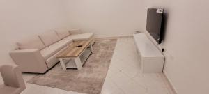 a living room with a couch and a table at HARF22G02-02 stylish 2BR in AD in Abu Dhabi