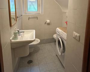 Un baño con lavabo y lavadora. en Movidart house, en Gaeta