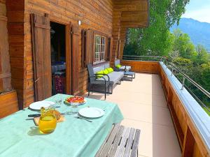 a patio with a table and chairs on a balcony at SwissHut Stunning Views Alps Lake - Chalet Emmit in Sigriswil