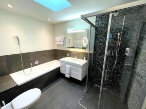 a bathroom with a shower and a toilet and a sink at SwissHut Penthouse 10min Interlaken West Station - Apart. Blume 2 in Interlaken