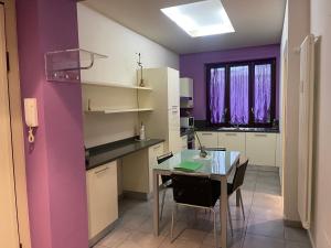 a kitchen with a table and a purple wall at Casa Violetta in Alba +7 photos