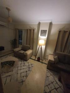 un soggiorno con 2 divani e una lampada di TREE Serviced Apartment -2BHK Self check-in a Il Cairo