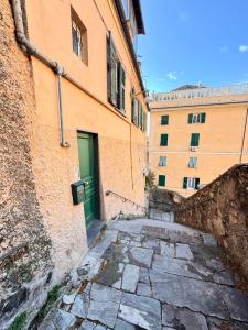 un callejón con una puerta verde en un edificio en GENOVA Suites SANT'UGO, en Génova