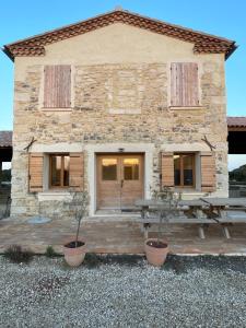 a stone building with a picnic table in front of it at Nuits Salines Aigues-Mortes in Aigues-Mortes