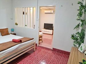 a bedroom with a bed and a tv in a room at whole house for 5 guests 3 beds in Hat Yai +4 photos