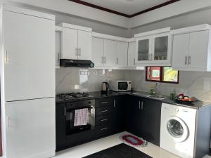 a kitchen with white cabinets and a washer and dryer at Casa Bianconera in Colombo