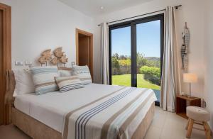 a bedroom with a bed and a large window at Villa Marita Luxury Sea View Chia in Santa Margherita di Pula