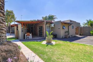 a house with a porch with a grass yard at Bosveld In Die Stad 2 Guesthouse in Alberton
