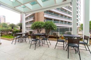 a patio with tables and chairs and a building at Diária Business - Sala VIP - Não Possui Cama e Chuveiro in Brasilia +27 photos