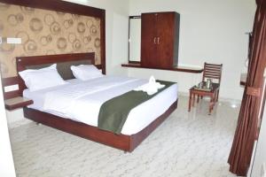 a bedroom with a bed with a white flower on it at Jeyam Palace by Whynter Stays in Kodaikānāl +10 photos