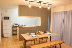 a dining room with a table and a kitchen at 杏々anan in Kagoshima