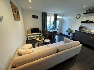 een woonkamer met een bank en een keuken bij Vakantiewoning aan de Kust 16 in Egmond aan Zee +24 foto's