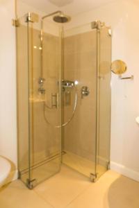 une douche avec une porte vitrée dans une salle de bain dans l'établissement Ferienresidenz Haus Vogelflug Fehmarn-Ostseeferien "Meerblick-Fehmarnsund" Strandresidenz Vogelflug 147 6, à Fehmarnsund
