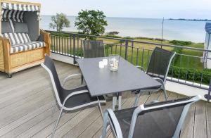 une table et des chaises sur un balcon avec l'océan dans l'établissement Ferienresidenz Haus Vogelflug Fehmarn-Ostseeferien "Meerblick-Fehmarnsund" Strandresidenz Vogelflug 147 6, à Fehmarnsund