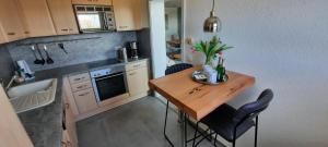 a small kitchen with a wooden table and chairs at Hafenglück in Fehmarn