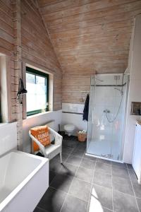 a bathroom with a shower and a tub and a toilet at Fehmarn Ostseeferien Landliebe Fehmarn 117 in Fehmarn +22 photos