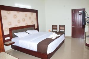 a bedroom with a large bed with white flowers on it at Jeyam Palace by Whynter Stays in Kodaikānāl