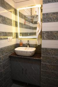 un baño con lavabo y espejo en Kartikey Home Stay, en Varanasi
