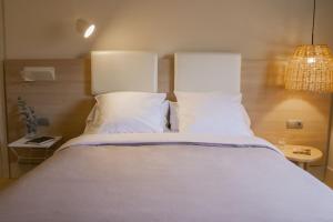 a large bed with white sheets and pillows at Select Bilbao in Bilbao +23 photos