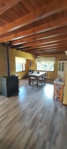 普埃洛湖Hostel La llegada的大型客房铺有木地板,配有桌椅。