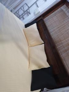 eine Nahaufnahme eines Bettes mit zwei Kissen darauf in der Unterkunft Green rooms in Weligama