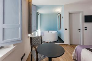 a small room with a table and a bath tub at Hotel Priori Secret Garden in Perugia