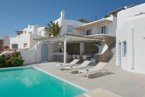 una villa con piscina e una casa di Marvelous 7 BR Villa Overlooking the Psarou Bay a Psarou