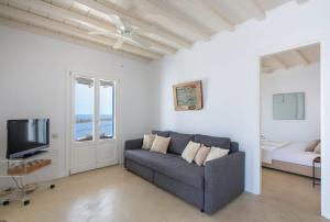 un soggiorno con un divano e una TV di Marvelous 7 BR Villa Overlooking the Psarou Bay a Psarou