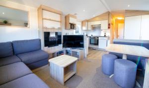 a small living room with a couch and a table at Gardens 3 - Coghurst Hall Hastings in Westfield