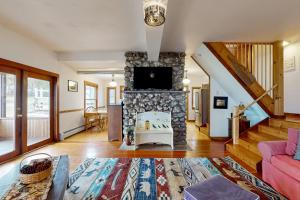 un soggiorno con camino in pietra con tv di Wildberry Cottage a Bomoseen