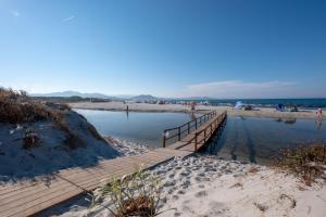a boardwalk leading to a beach with people on it at Happy Camp mobile homes in Selema Camping in Santa Lucia