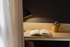 an open book on a desk with a potted plant at Select Bilbao in Bilbao